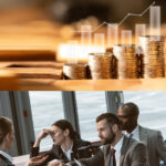 double image: image of coins on top, businesspeople talking on bottom