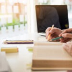 Two CMP students study for the CMP exam together over an open book