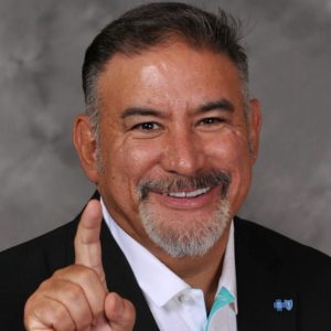 man smiling, wearing white dress shirt and black sport coat