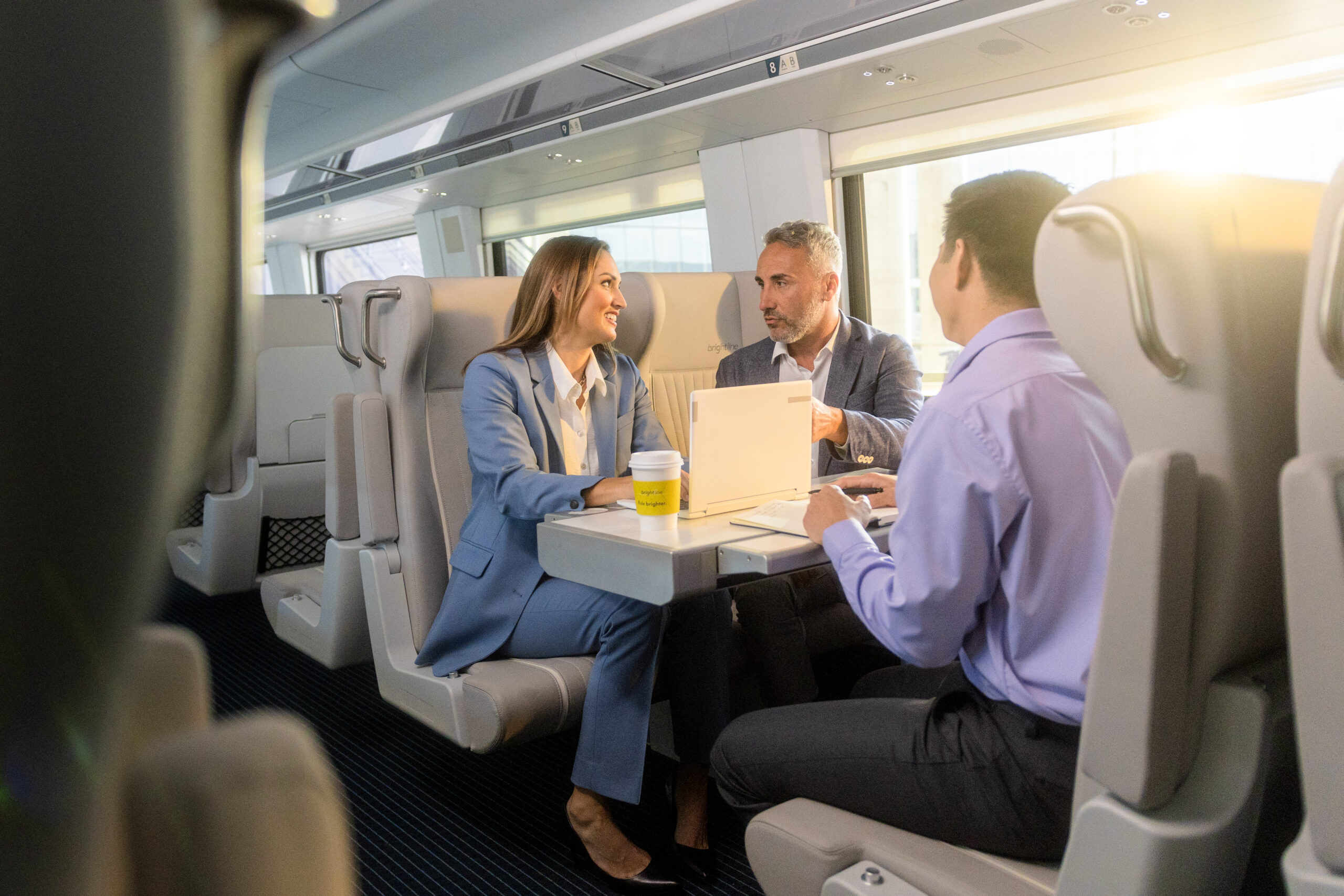 three businesspeople in talking in train