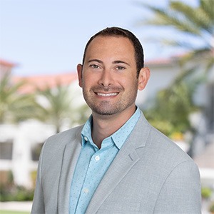 man wearing blue dress shirt and light grey coat