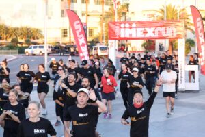 runners in black crossing the finish line at IMEXrun