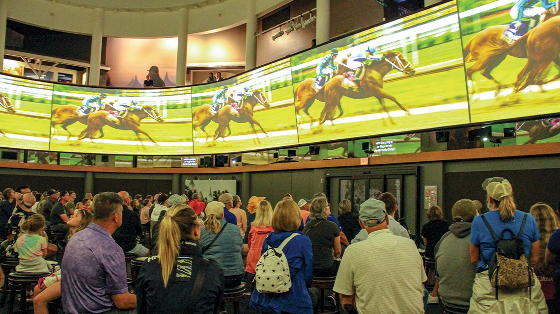 people watching horse race at museum