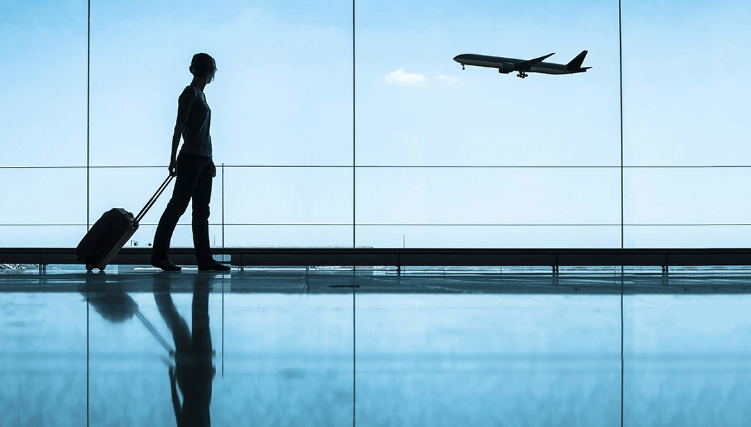 Person in airport watching a plane take off