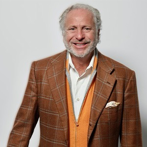 man in dark orange suit smiling
