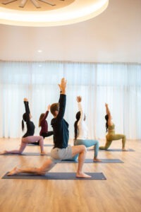 five people practicing yoga in studio