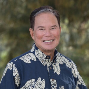 man in blue button up short smiling