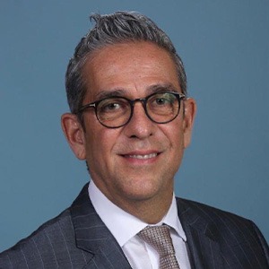 headshot of man in glasses smiling