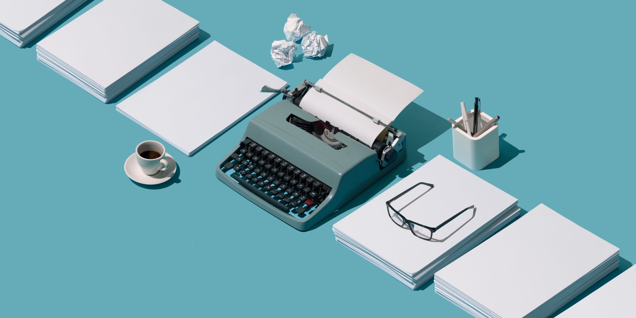 typewriter and reams of paper on blue background