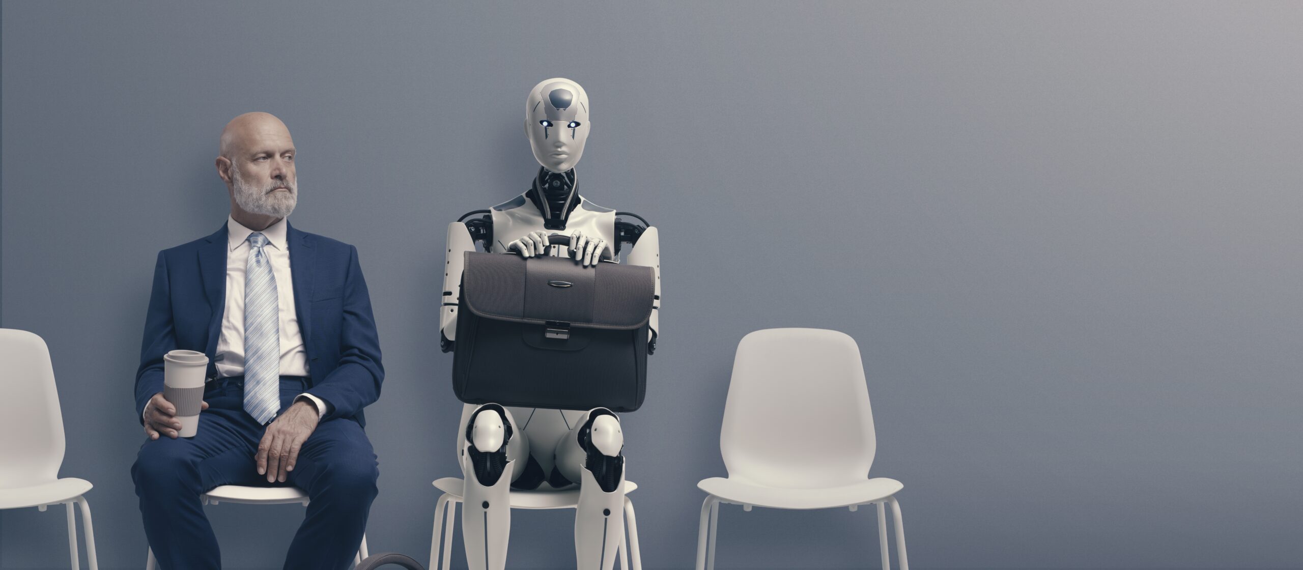 man sitting next to robot