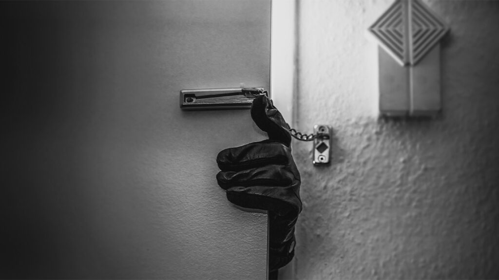 black and white image of gloved hand grabbing door