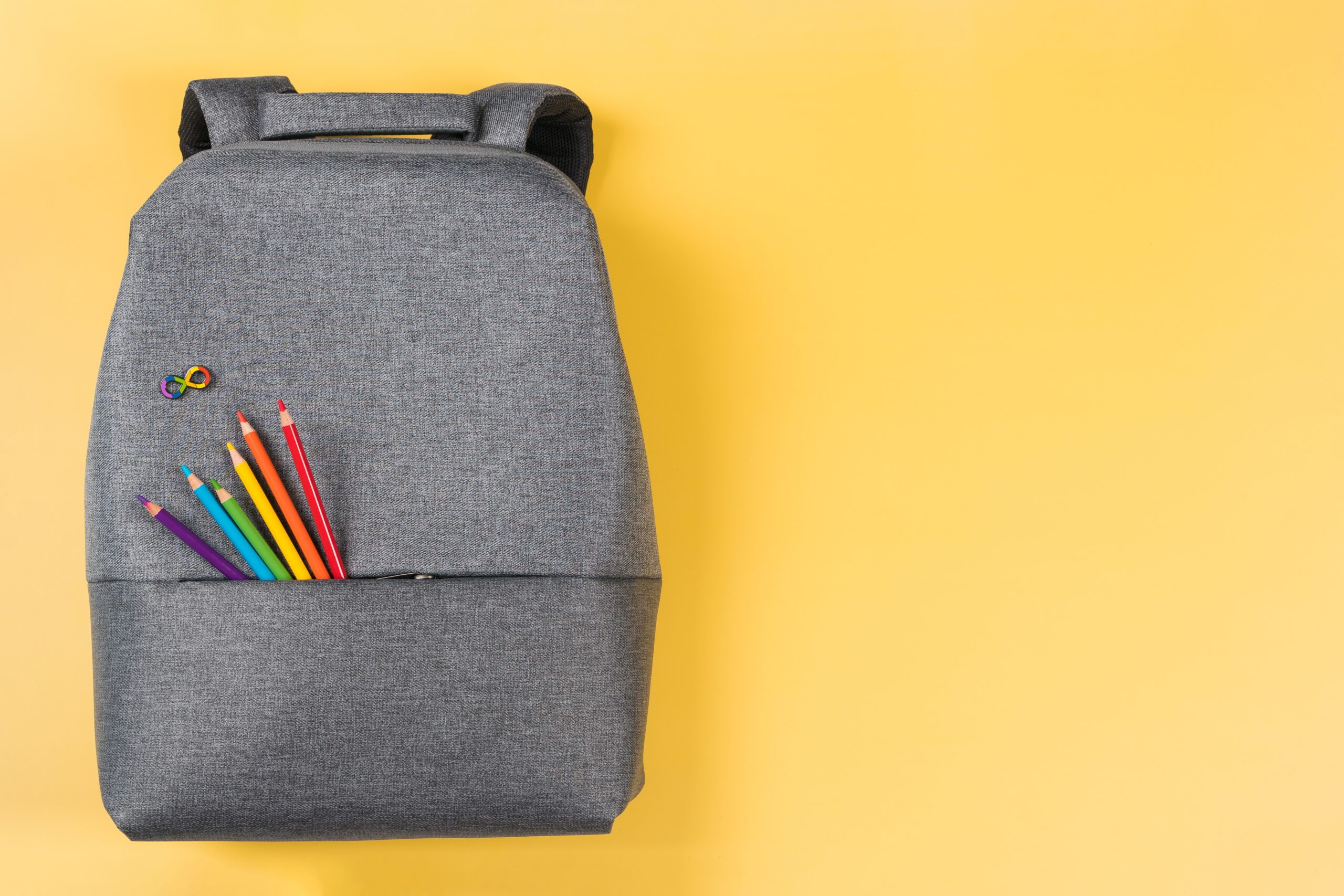 grey backpack on yellow background