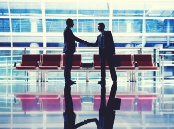 two men shaking hands in airport