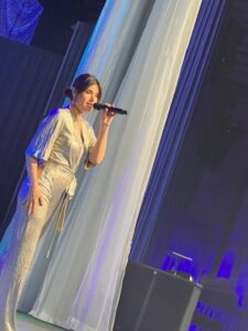 singer Idina Menzel in silver jumpsuit singing