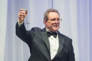 Marty Brooks, Wisconsin Center District CEO and President at Baird Center Expansion Grand Opening Gala making a toast in a tuxedo.
