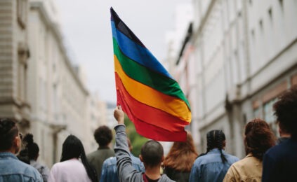 person holding colorful gay pride flag