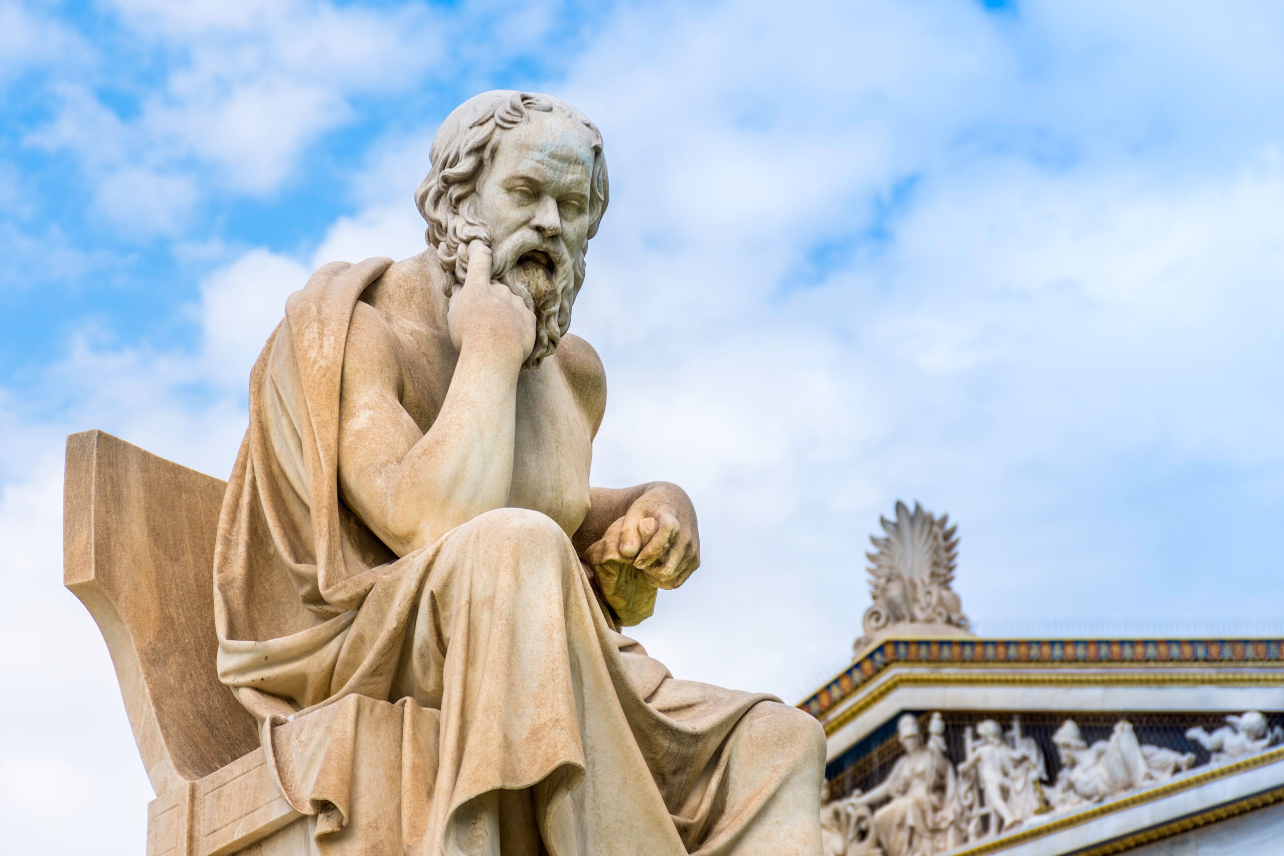 marble statue of man resting head on right hand