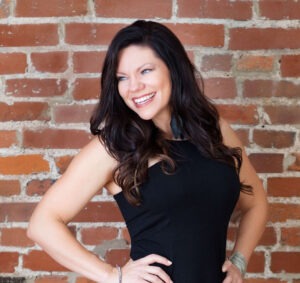 Heather Crider wearing black dress against brick wall