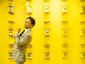 Nash Fung wearing yellow plaid suit against yellow background