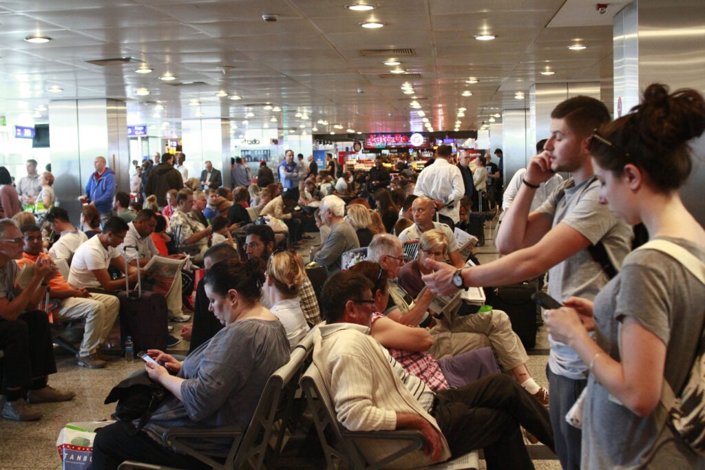 Tourists are waiting in a crowded space at airport