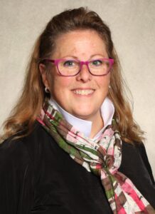 Laurie Fitzgerald wearing black coat, white shirt and colorful scarf