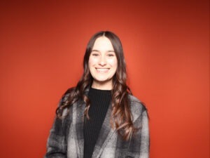 Shannon Fouts smiling in front of red backdrop