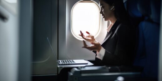 businesswoman on airplane talking into earphone