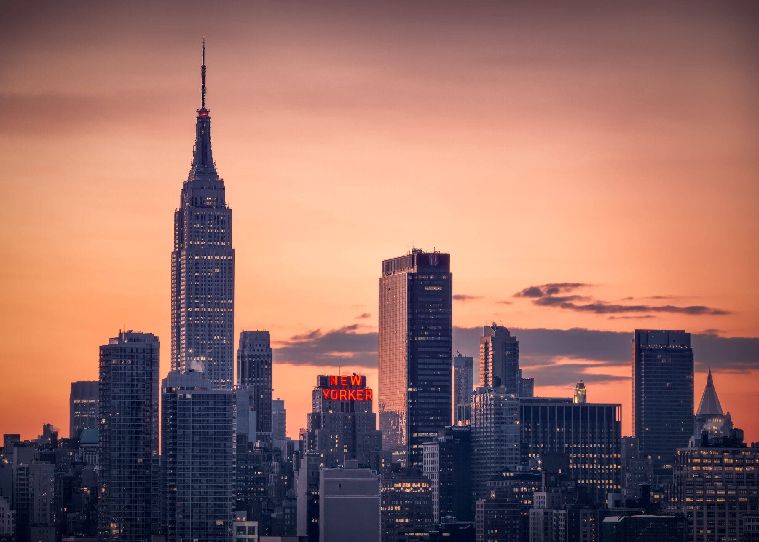 Sunrise over Manhattan skyline with "New Yorker" sign lit up