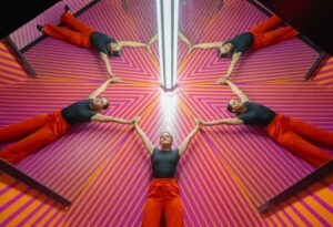 five people laying down and forming a star at Museum of Illusions