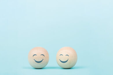 two wooden spheres with happy faces on them