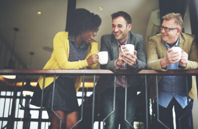 three people talking and drinking coffee