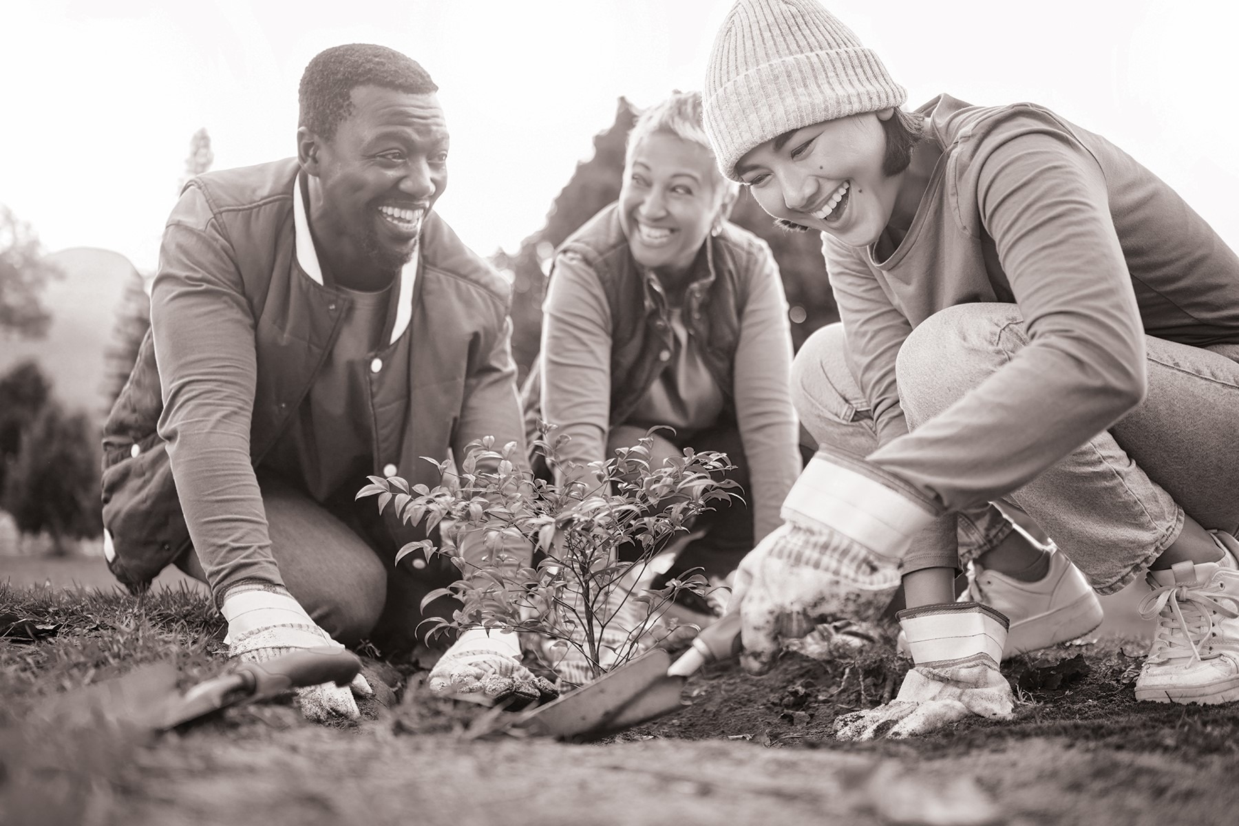 black and white image of three people planting for csr