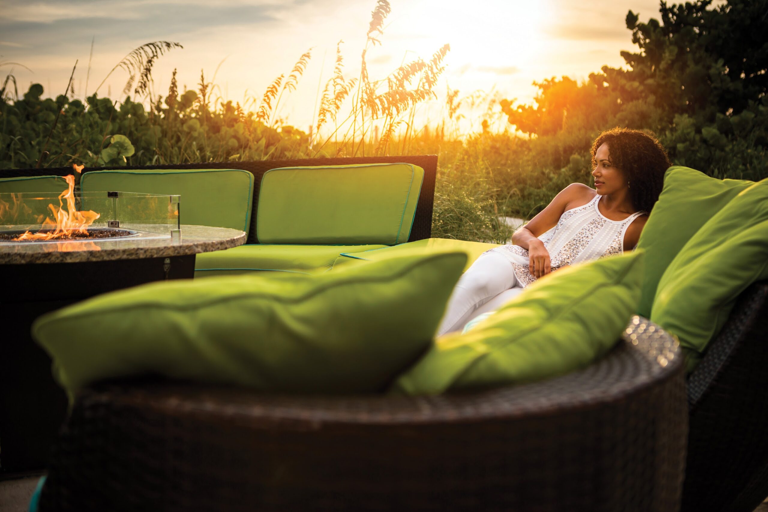 Woman laying on couch at Rumfish Beach Beach Lounge & Firetable