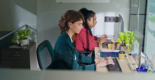 Two Gen Z business women using laptop