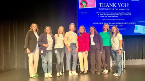 Eight women standing next to each other on stage