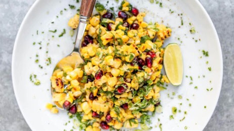 Plate of corn, pomegranate seeds and lime