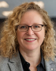 Close up of Wendy Porter wearing glasses, grey sport coat and black collared shirt