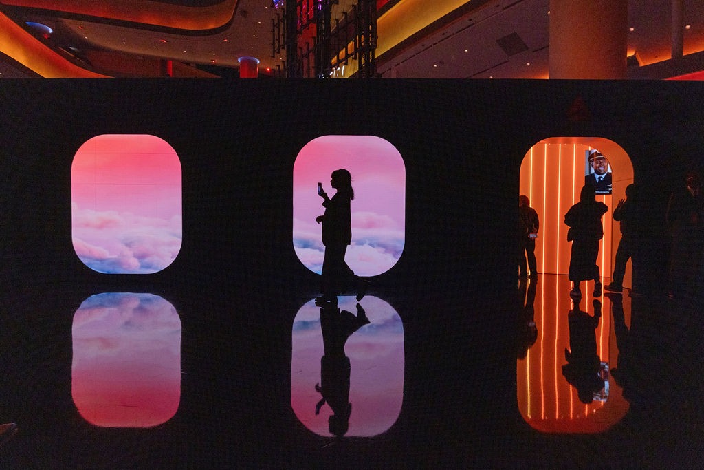 Silhouette of woman walking across image of sky