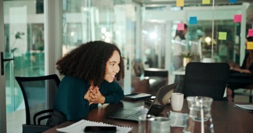 Businesswoman smiling at laptop screen