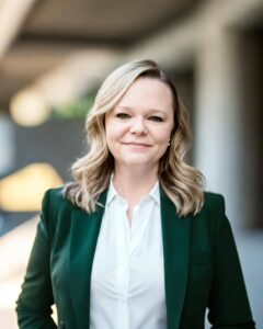 Jennifer Little wearing green coat and white shirt