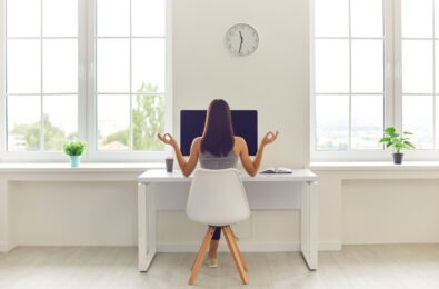 Woman meditating at work desk