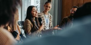 Woman talking and engaging in a debate with peers during a group meeting