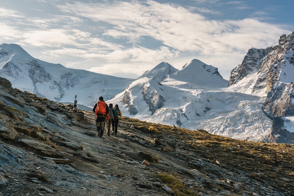 Group of backpacker hiking on alpine summit among swiss alps at Zermatt, Switzerland