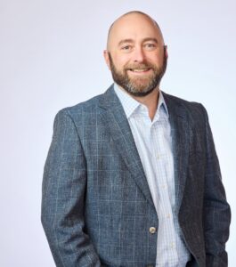 Todd Moritz wearing blue plaid sport coat and white dress shirt