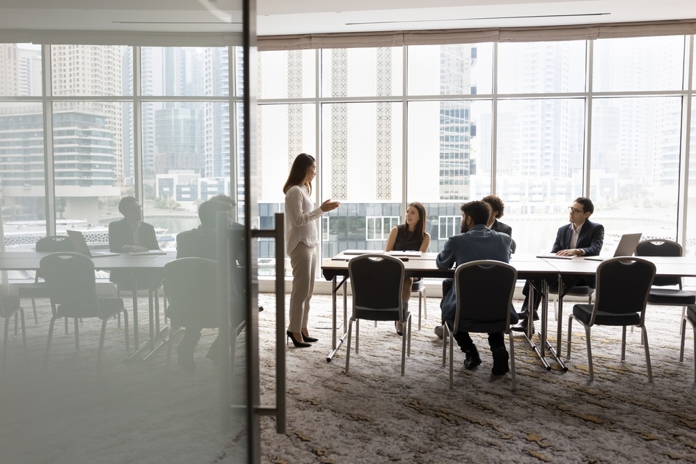 Wide shot of business team talking at meeting table in office conference room